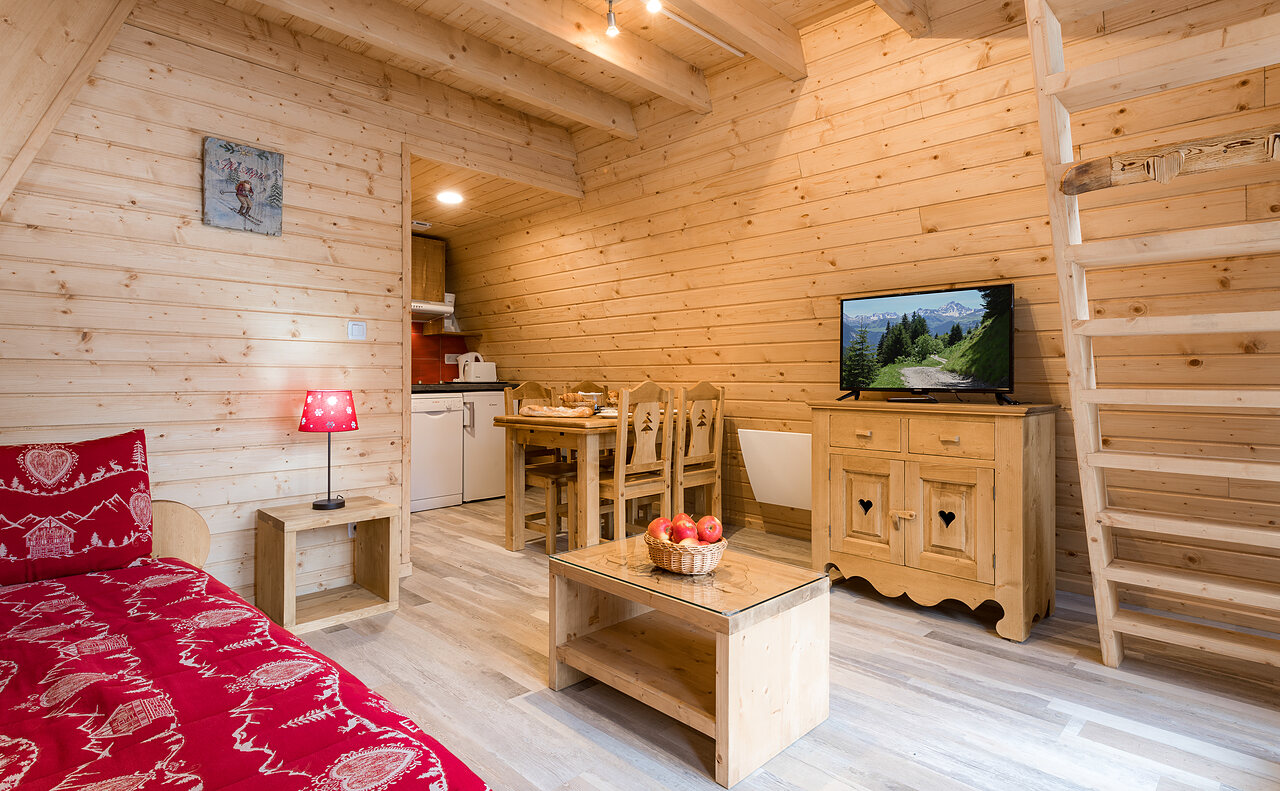 Wooden chalet, living room, kitchen and mezzanine at CLICOCHIC Alpes Lodges campsite in Pralognan la Vanoise (73).