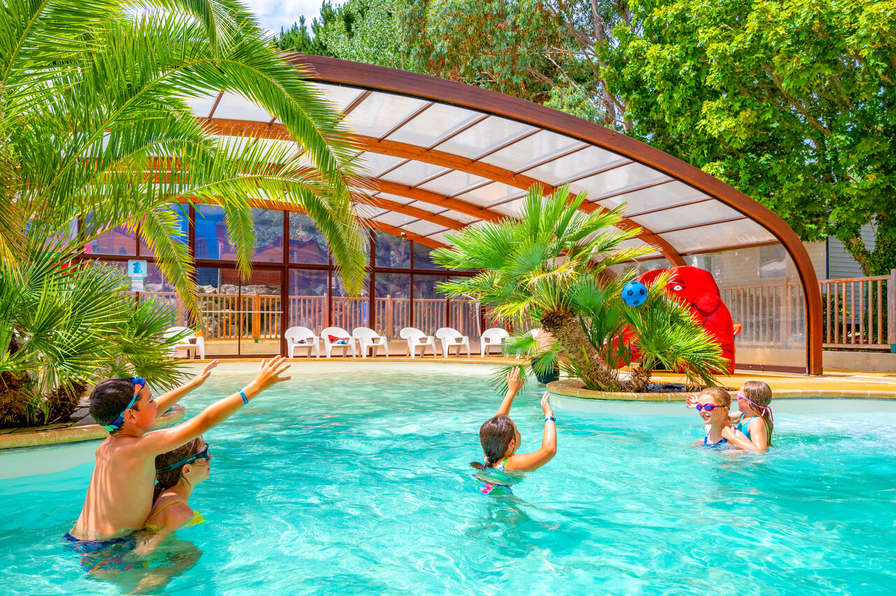 Piscine couverte avec toboggan et enfants jouant au camping CAPFUN An Trest � SARZEAU (56).