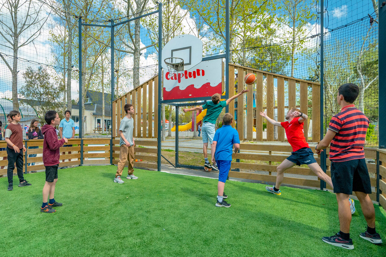 Terrain multisport avec jeunes jouant au basketball au camping CAPFUN Armor H�ol � Piriac sur Mer (44).