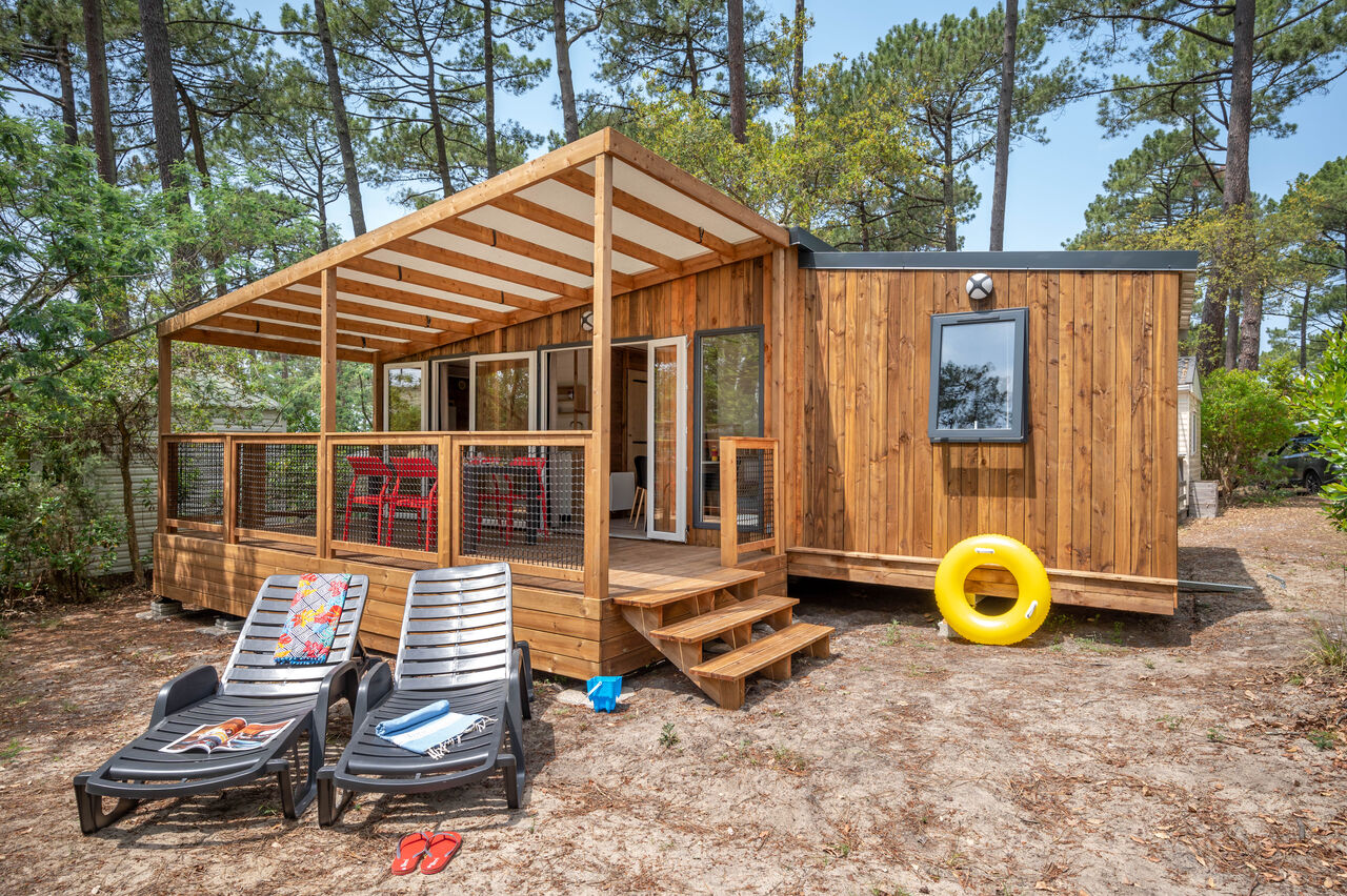 Mobile home en bois, terrasse couverte, transats au camping LIBRANOO Naturiste Arnaoutchot, Landes.