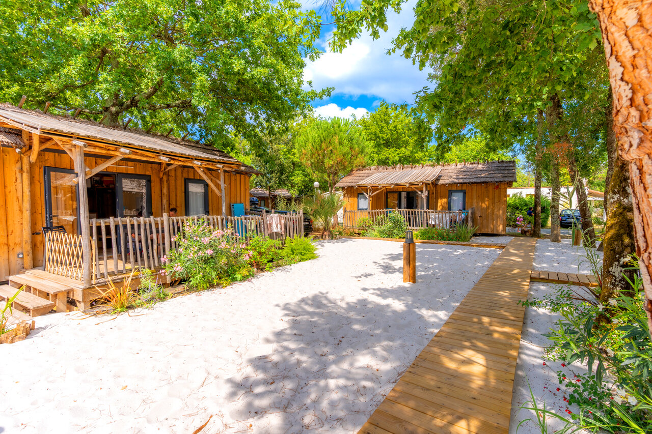 Chalets en bois, toits de chaume, plage de sable au camping CAPFUN Atlantique Parc � Les Mathes / La Palmyre.