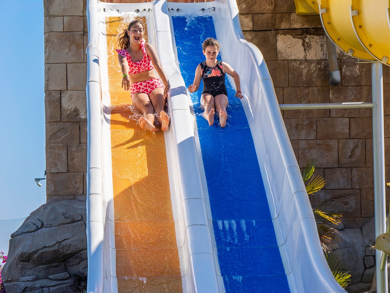 Deux filles joyeuses sur un toboggan aquatique au camping CAPFUN Aube � Deltebre, Tarragone.