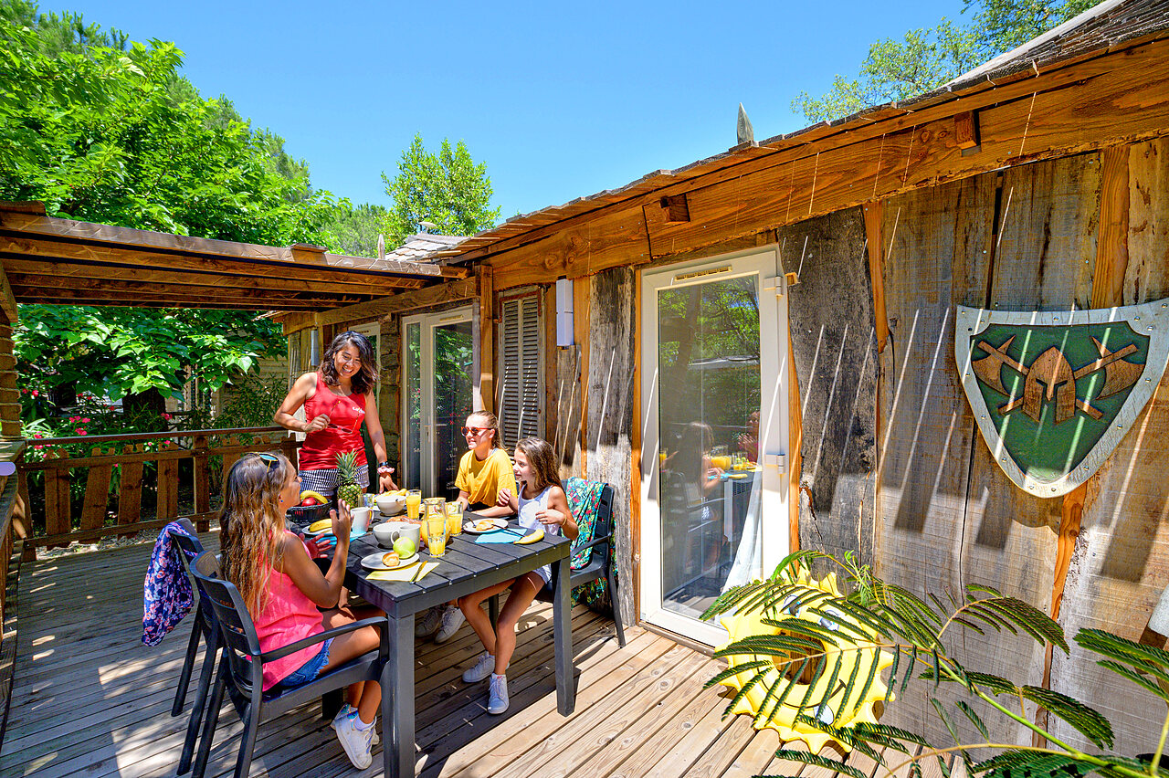 Chalet, famille d�jeunant sur terrasse au camping CAPFUN Aubr�des � Puget sur Argens.