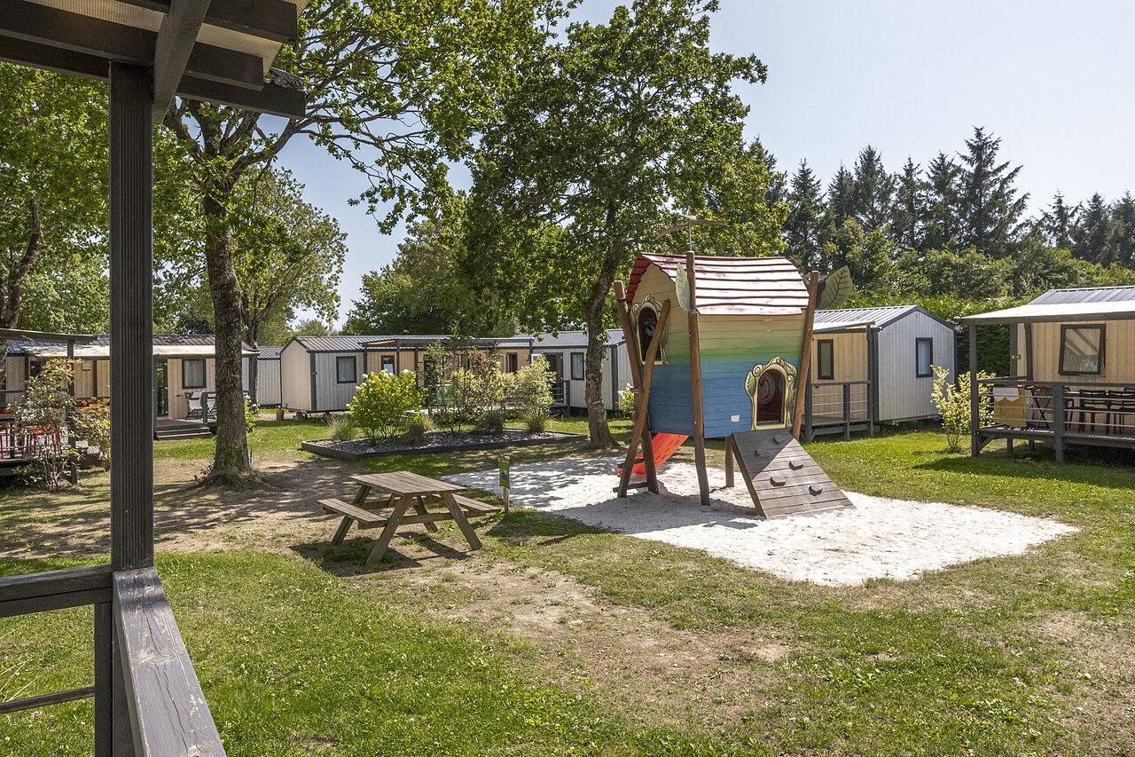 Aire de jeux enfants, cabane, toboggan et mobile-homes au camping CLICOCHIC � Poullan-sur-Mer.
