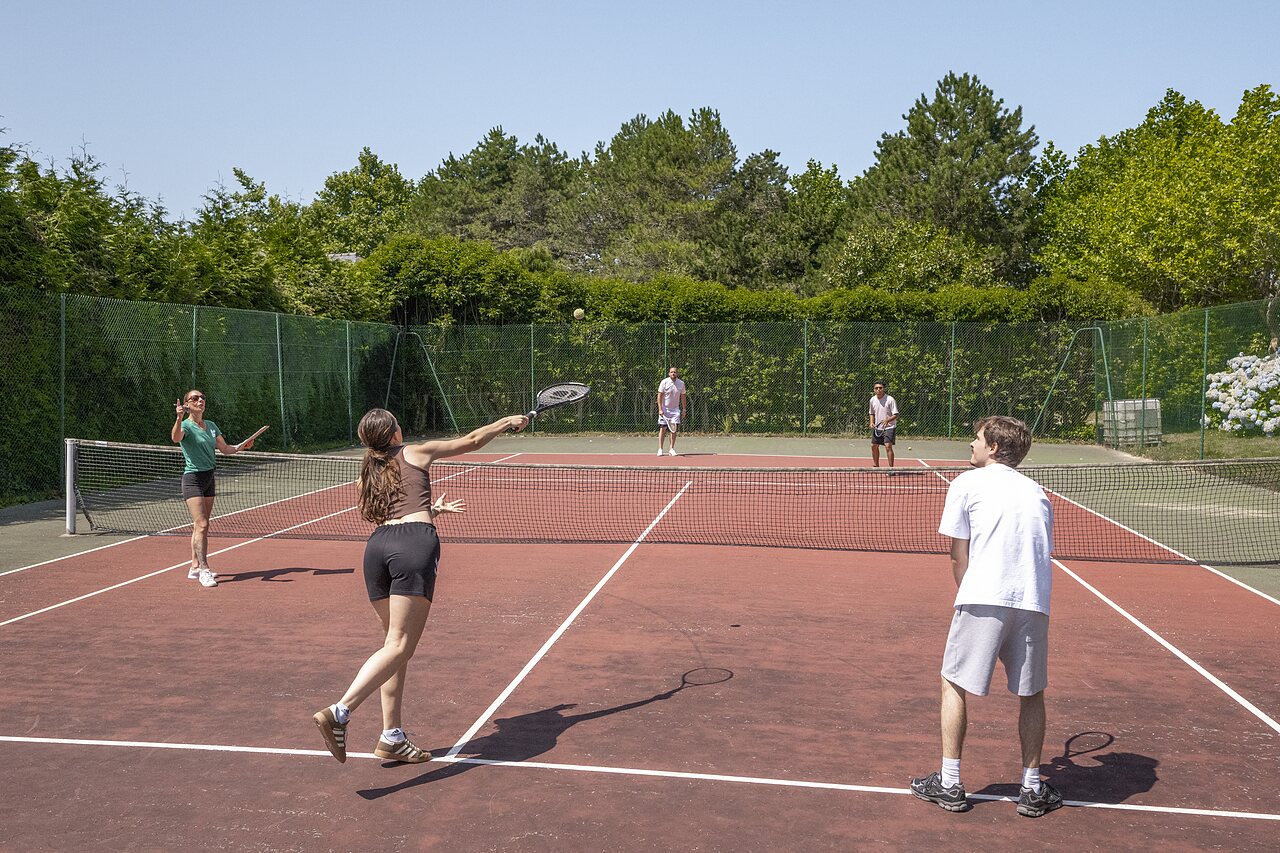Joueurs de tennis sur le court ext�rieur au camping CLICOCHIC Baie de Douarnenez.