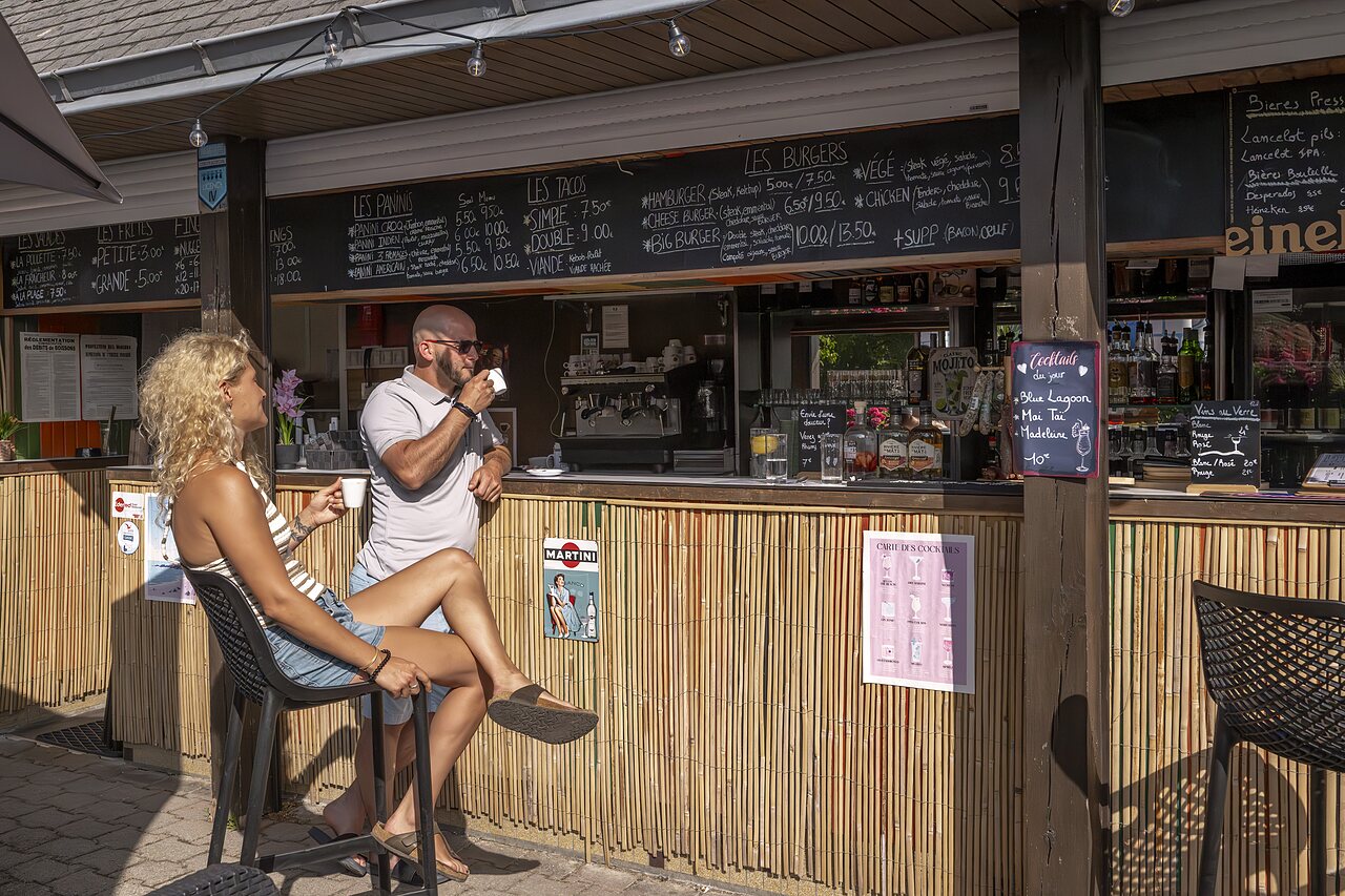 Bar-restaurant avec terrasse, clients d�gustant boissons et repas au camping CLICOCHIC Baie de Douarnenez.