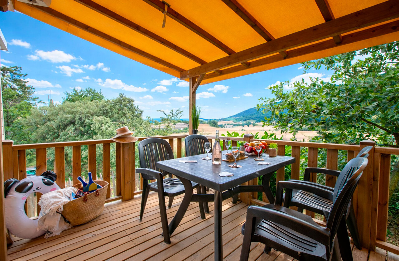 Terrasse d'h�bergement, table, chaises, vue nature au camping CLICOCHIC Bastets � Marsanne (26).