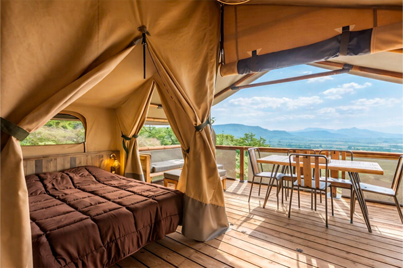 Tente lodge glamping, lit, terrasse, vue panoramique au camping CLICOCHIC Bastets.