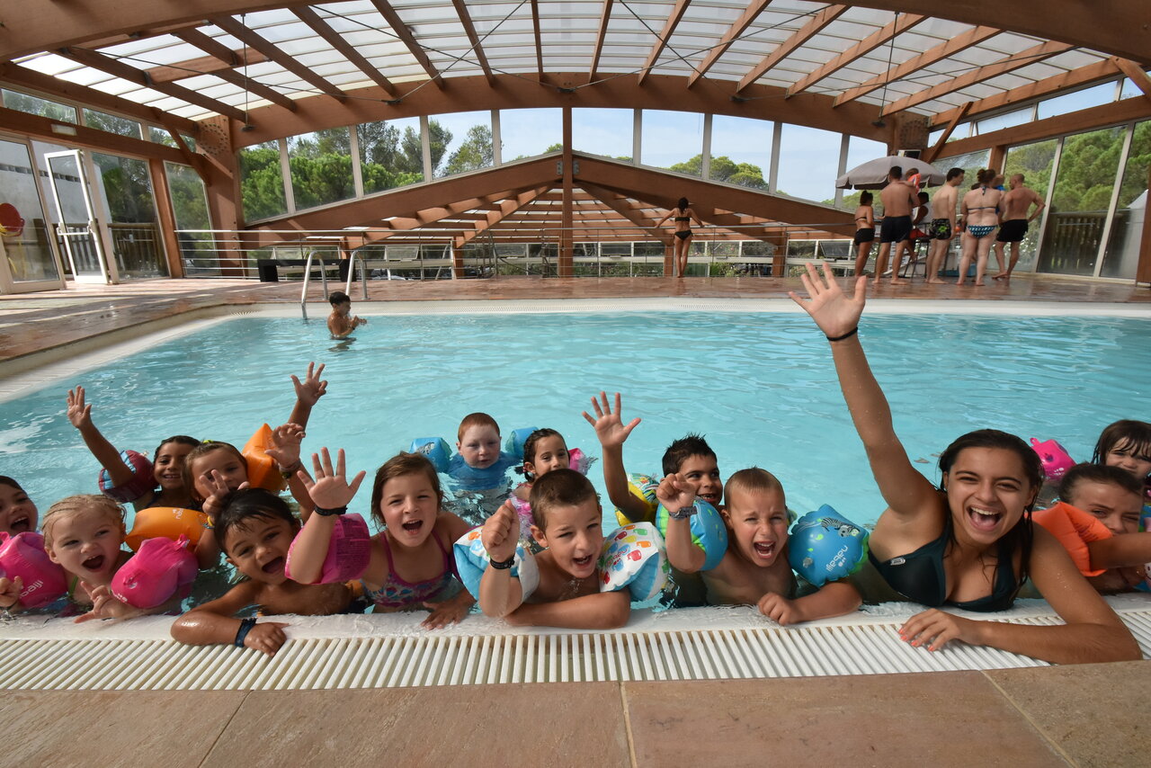 Enfants et animateur souriants dans la piscine couverte au camping CAPFUN La Baume - La Palmeraie � Fr�jus (83).