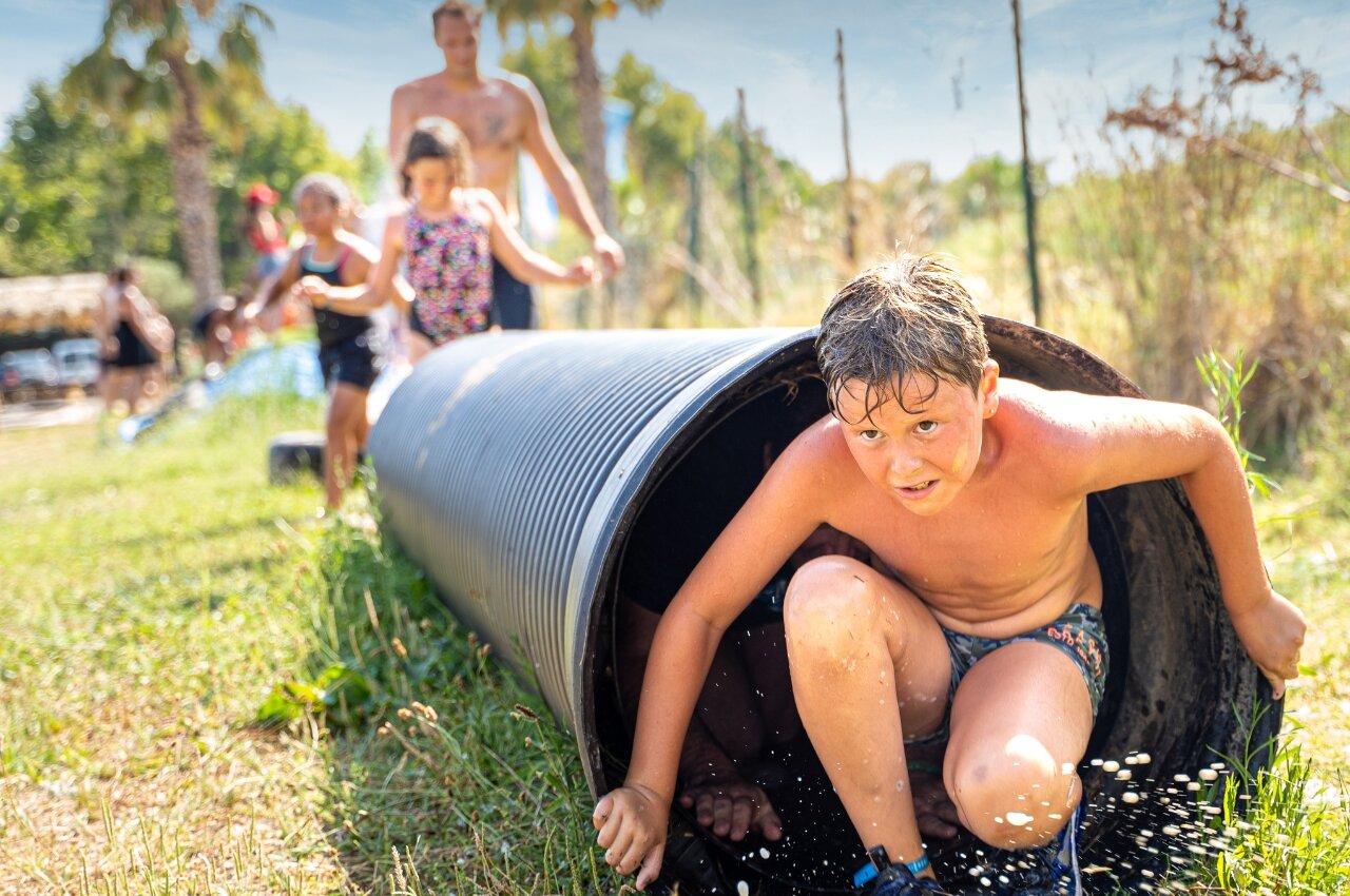 Enfant sortant d'un toboggan aquatique tubulaire au camping CAPFUN Beauregard � MORNAS (84).