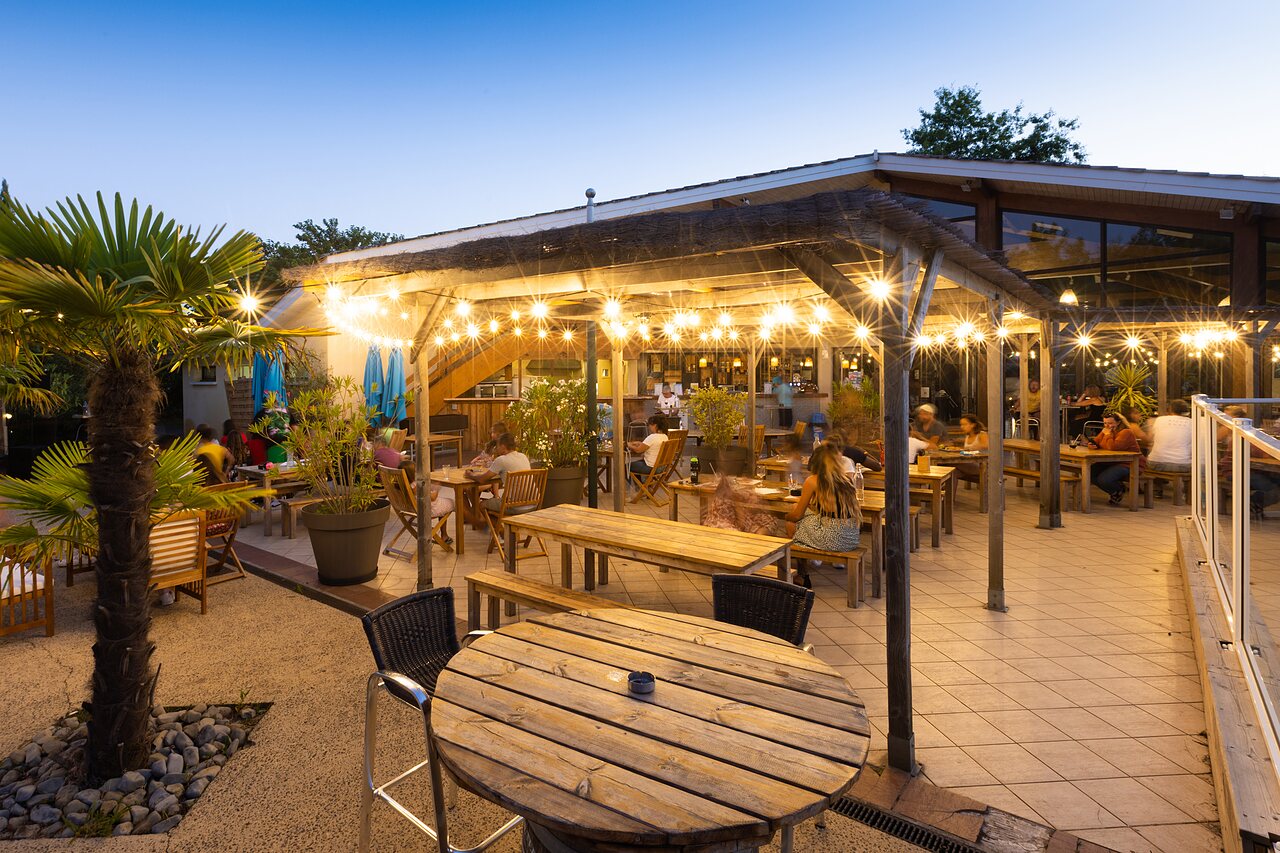 Terrasse de restaurant anim�e avec guirlandes lumineuses au camping CLICOCHIC Bimbo � BISCARROSSE (40).