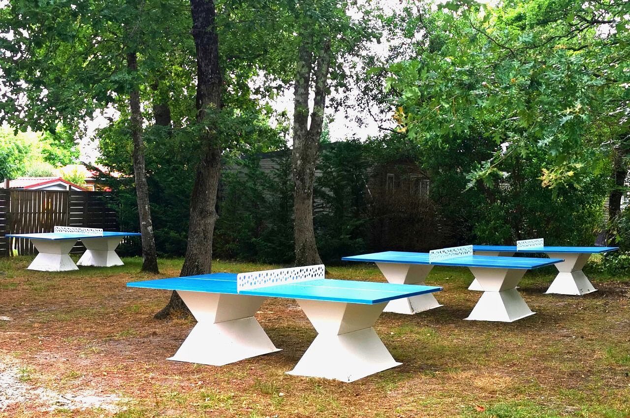 Tables de ping-pong ext�rieures bleues sous les arbres au camping CLICOCHIC Bimbo � BISCARROSSE (40).