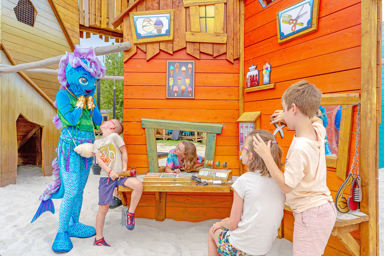 Enfants jouant avec mascotte et structure en bois au camping VAGUES OCEANES Bois Joly � Saint-Jean-de-Monts (85).