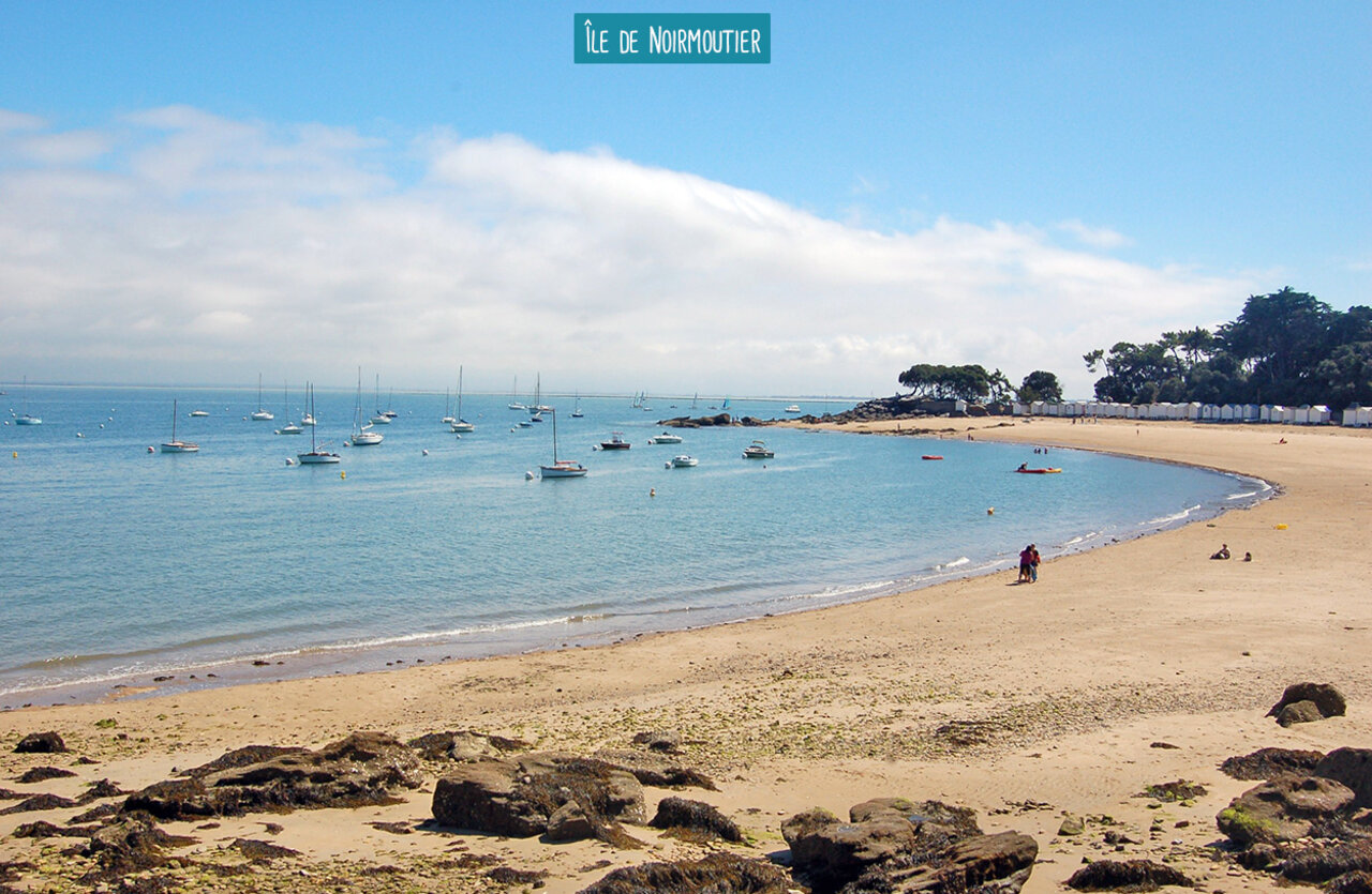 Plage de l'�le de Noirmoutier avec bateaux et cabines de plage.