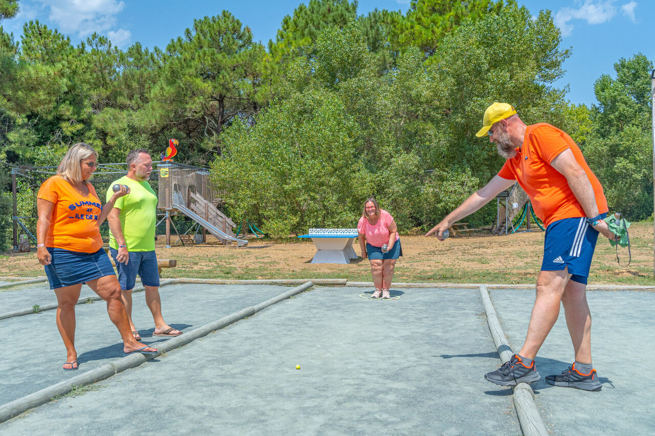 P�tanque entre adultes, jeux en arri�re-plan au camping CAPFUN Bonne Etoile � BOIS PLAGE EN RE (17).