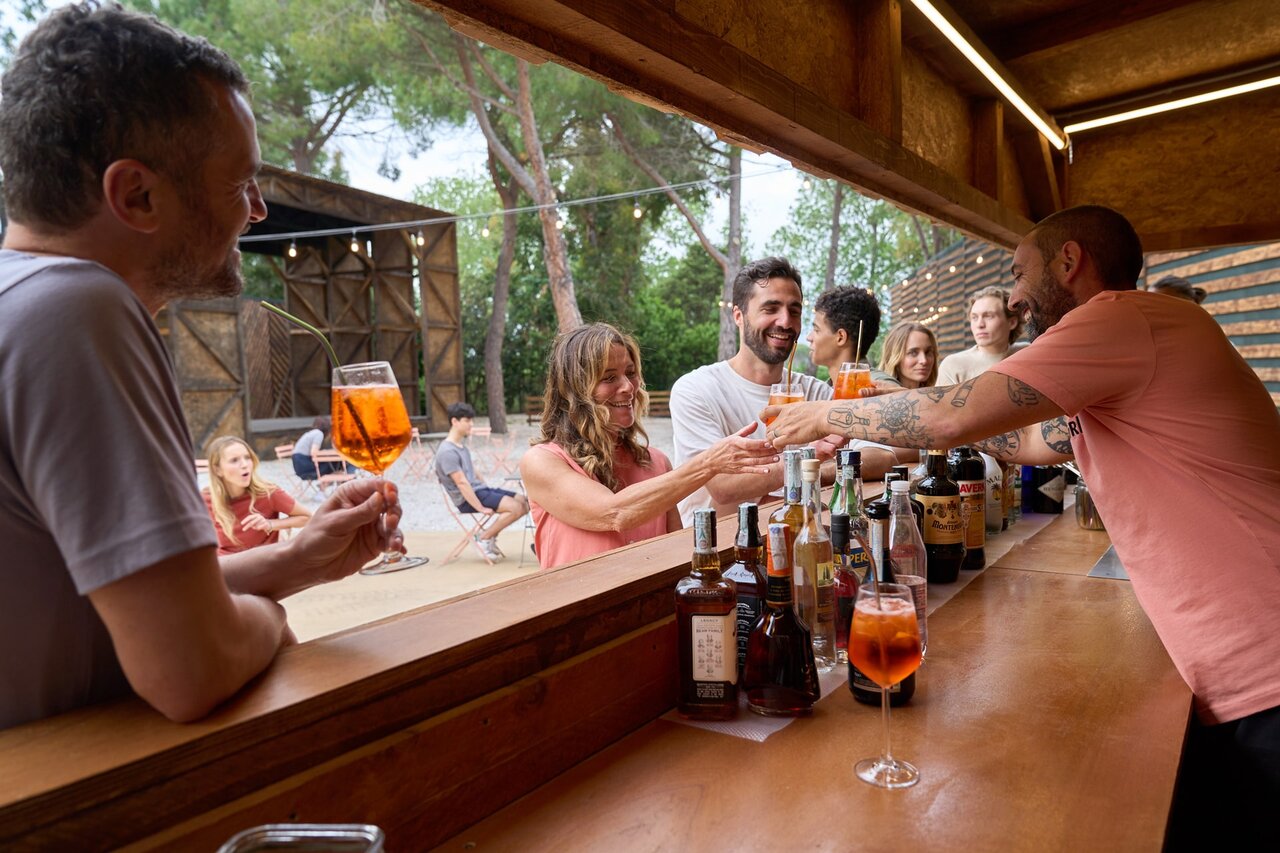 Bar ext�rieur anim� avec clients et barman au camping CAPFUN Campo dei Fiori � Rosignano Marittimo (57).