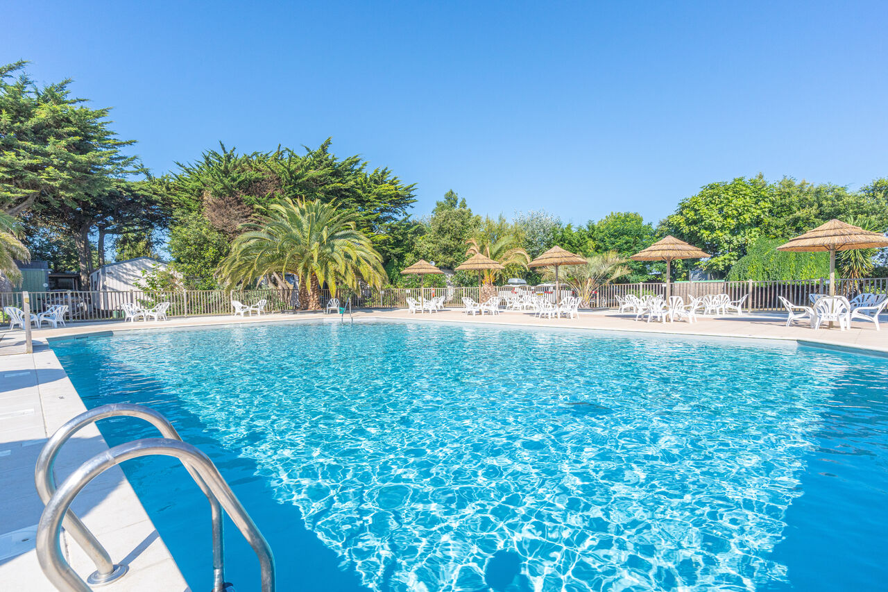 Piscine ext�rieure, transats et parasols au camping CLICOCHIC Camp du Soleil.