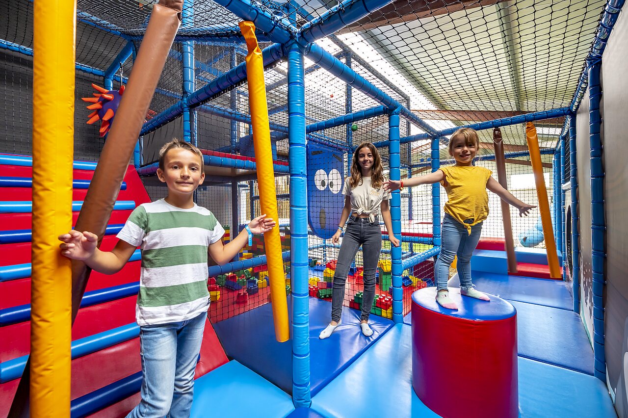 Aire de jeux int�rieure avec enfants et structures color�es au camping CAPFUN Cenic � PENESTIN.