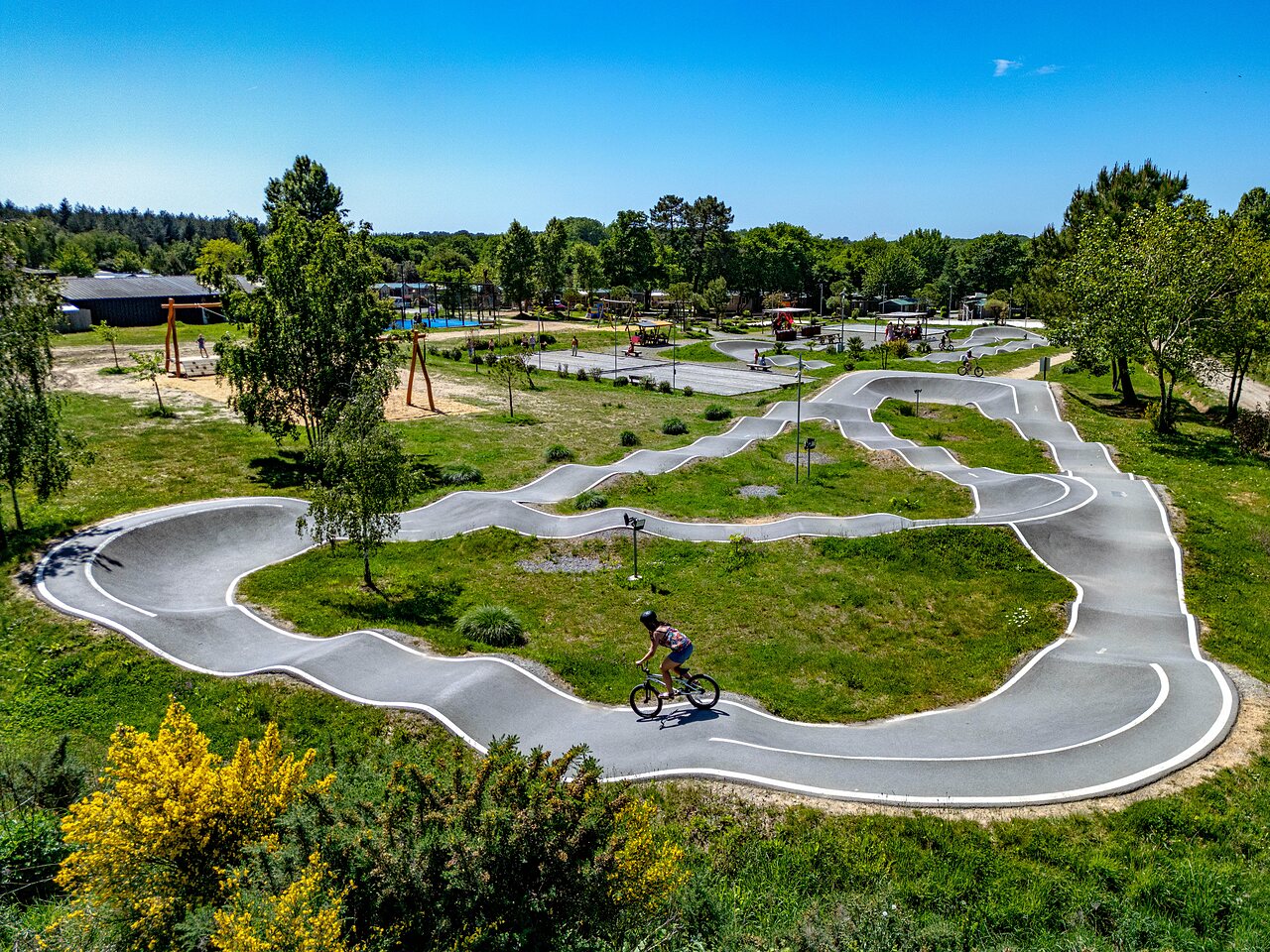 Pump track moderne avec cycliste, aire de jeux au camping CAPFUN Cenic � PENESTIN (56).