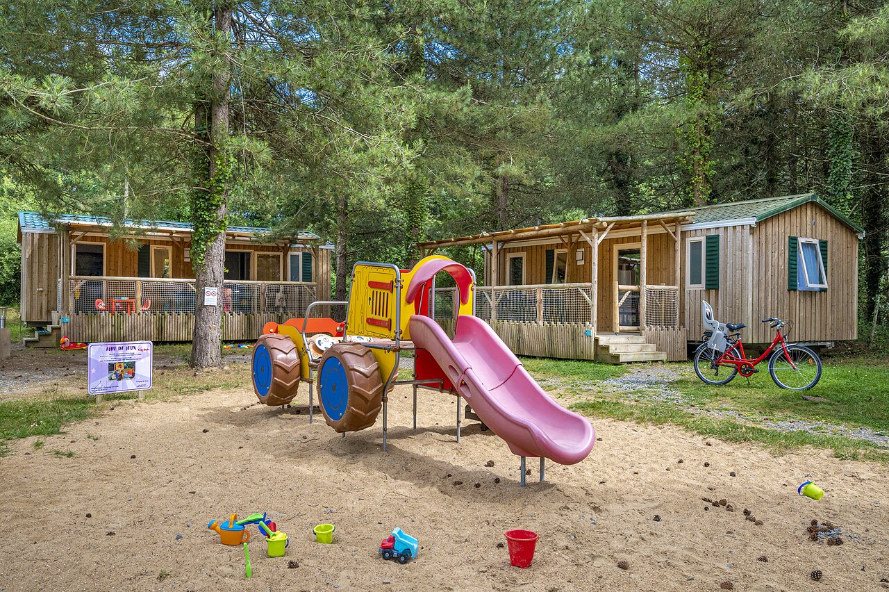 Aire de jeux avec toboggan et Mobil-homes au camping CAPFUN Cenic � PENESTIN (56).