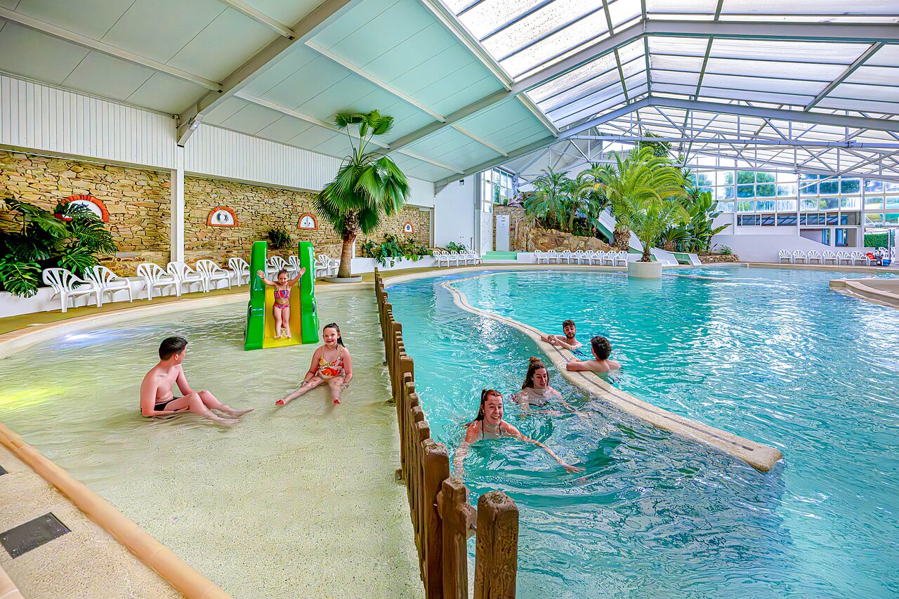 Piscine couverte avec toboggan, rivi�re et enfants au camping CAPFUN Cenic � PENESTIN (56).