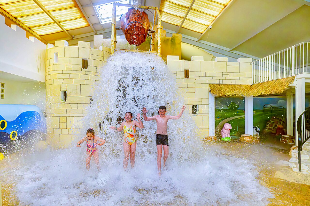 Enfants sous le seau g�ant d�versant l'eau � la piscine du camping CAPFUN Cenic � PENESTIN (56).