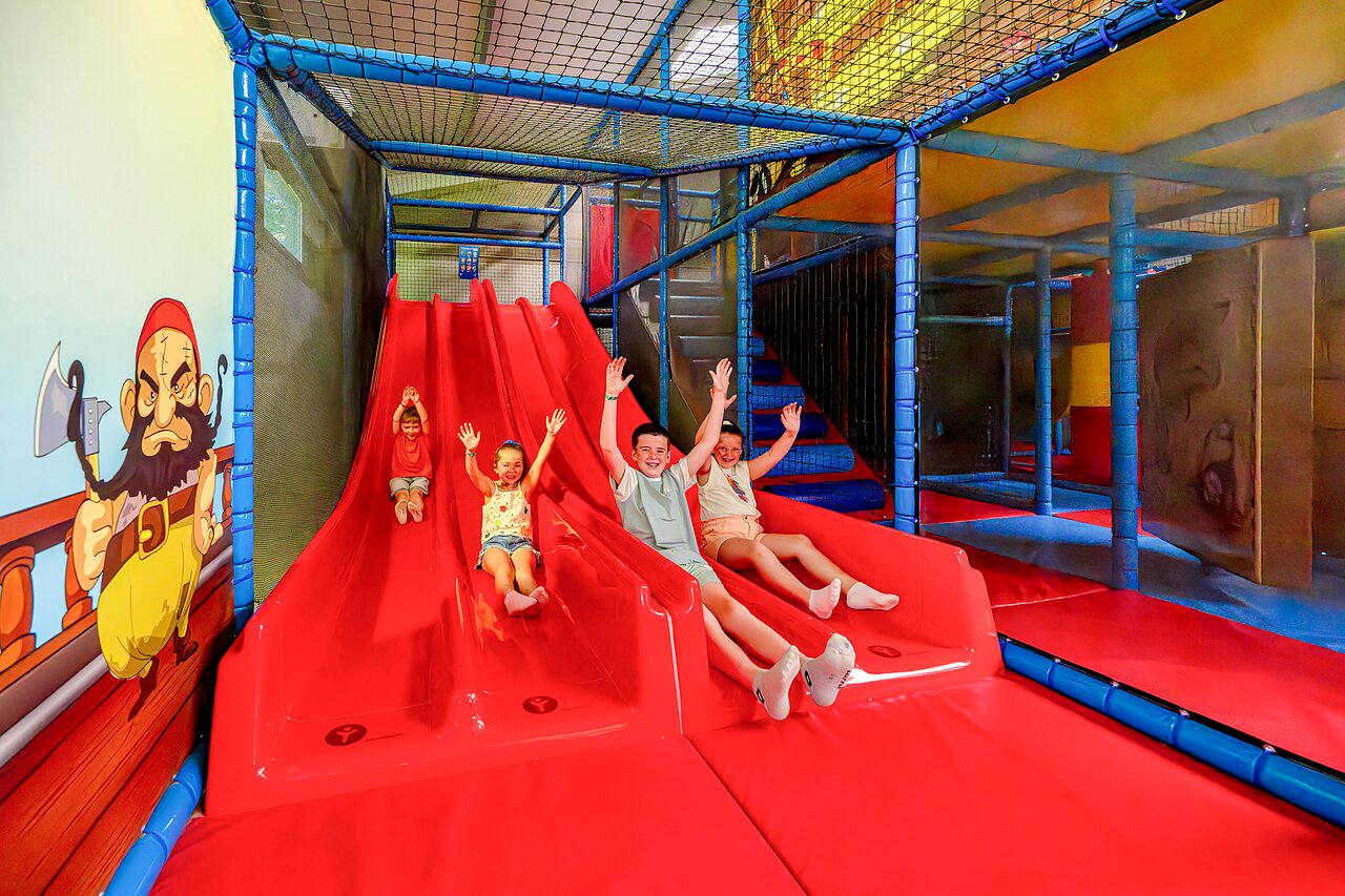 Aire de jeux int�rieure avec toboggans et enfants au camping CAPFUN Cenic � PENESTIN (56).
