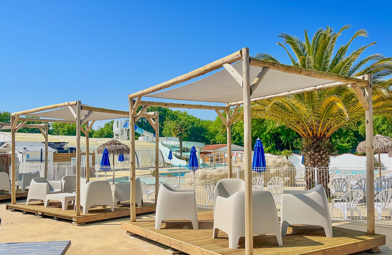 Espace d�tente ombrag�, piscine, toboggans au camping VAGUES OCEANES Domaine les Charmilles � Saint-Laurent-de-la-Pr�e (17).