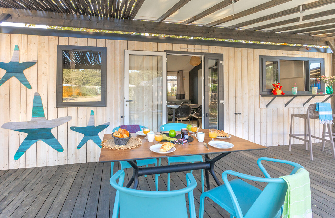 Petit-d�jeuner sur terrasse couverte de mobil-home moderne au camping VAGUES OCEANES Domaine les Charmilles � Saint-Laurent-de-la-Pr�e (17).