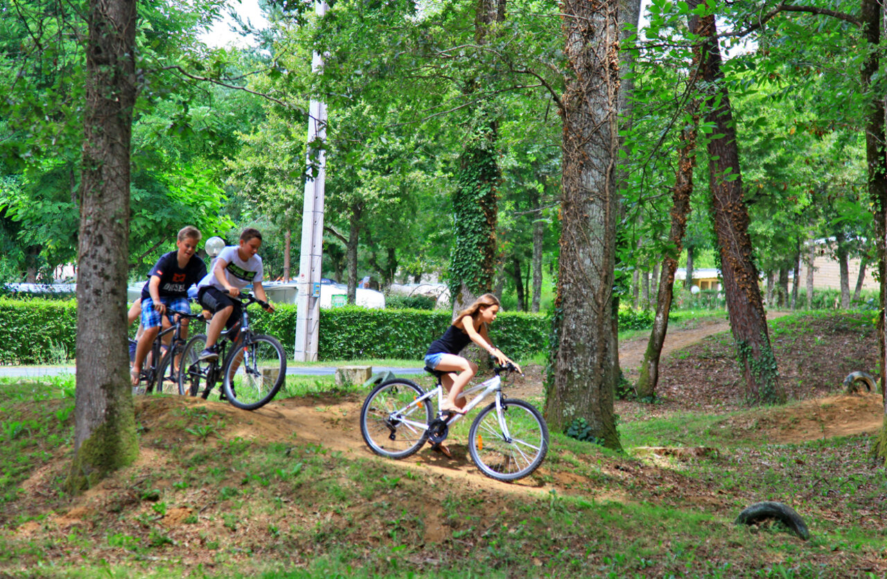 Jeunes cyclistes sur sentier au camping VAGUES OCEANES Chataigneraie Prats-de-Carlux.