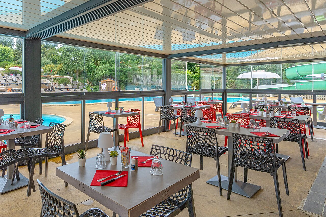 Restaurant moderne avec vue sur la piscine et toboggan au camping CAPFUN La Ch�naie � PORNIC (44).