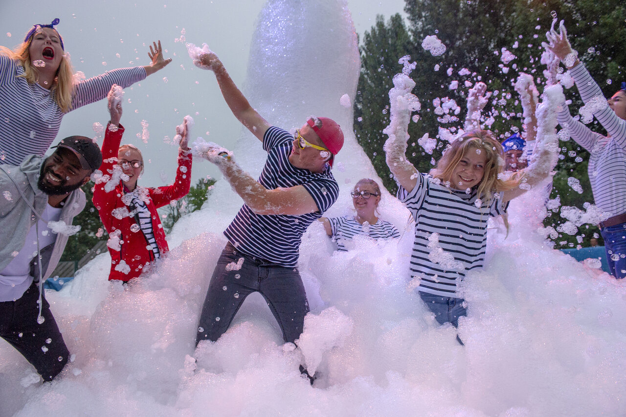 Levendig schuimfeest met kinderen en volwassenen op camping CAPFUN Citadelle de Loustic in Hermanville sur Mer.