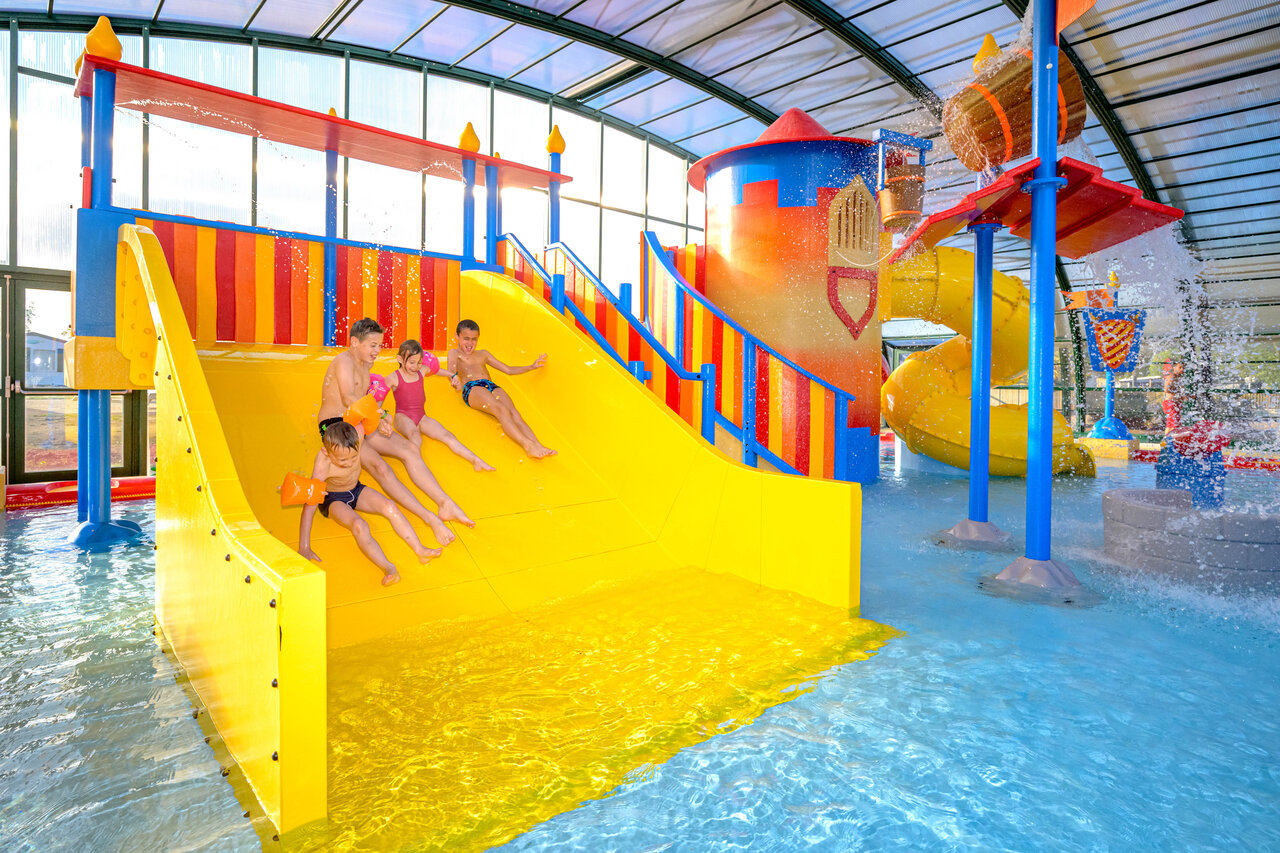 Overdekte waterglijbaan en waterspeeltuin voor kinderen op camping CAPFUN Citadelle de Loustic.
