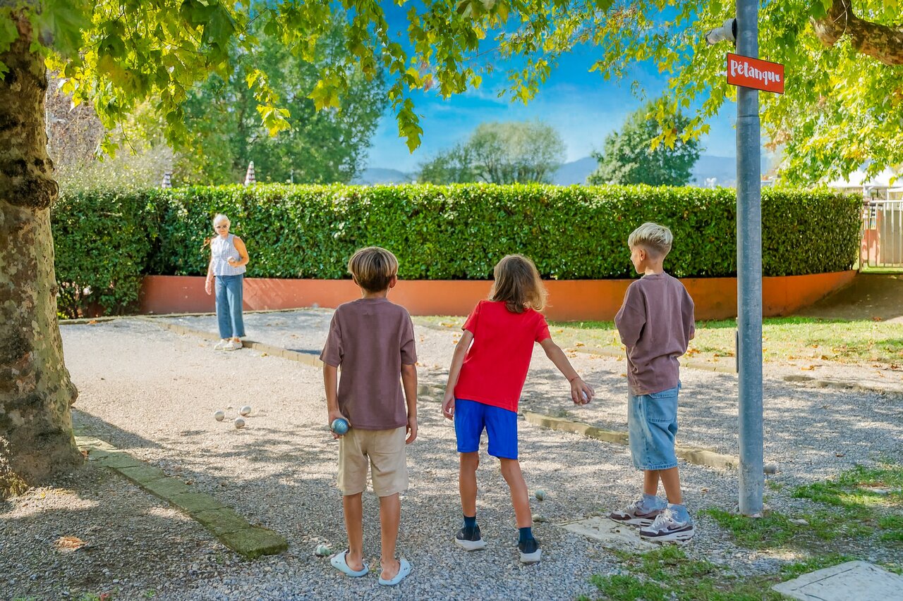 Enfants et adulte jouant � la p�tanque sur le terrain du camping CAPFUN Citta di Angera � Angera VA (21).