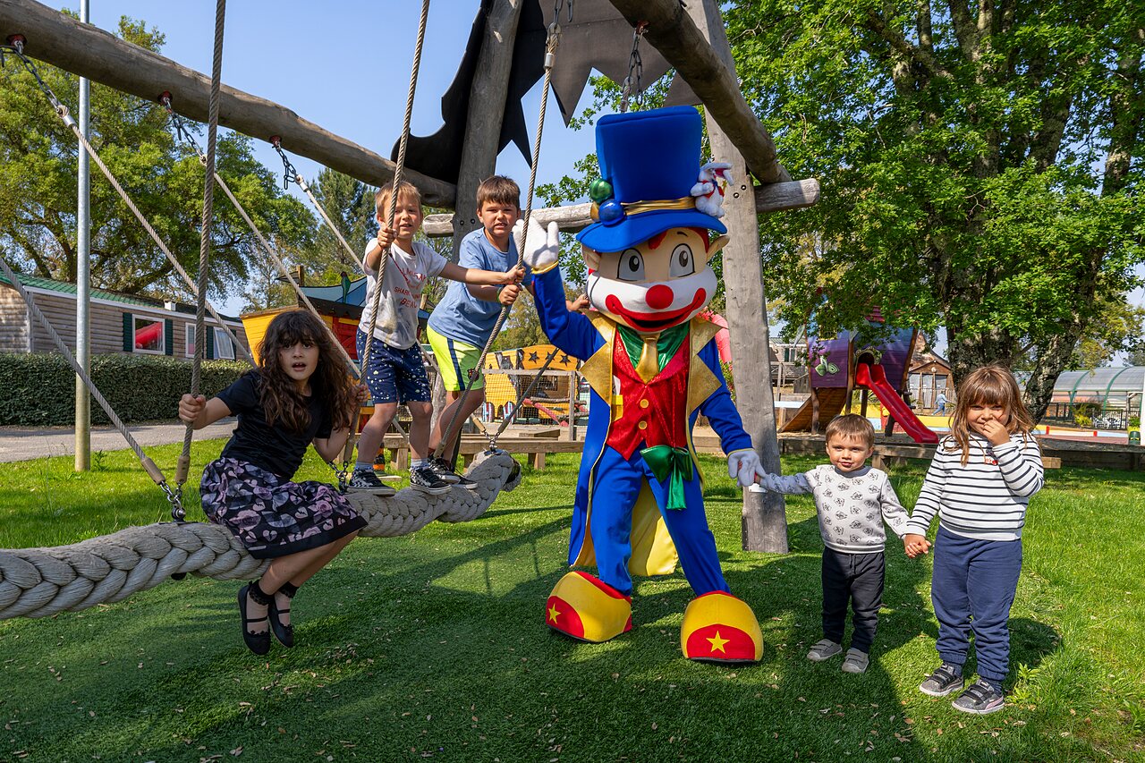 Enfants jouant avec la mascotte et sur les jeux au camping CAPFUN Clown Oc�an � TOSSE (40).