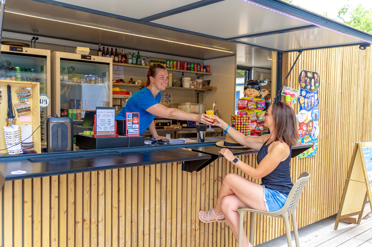 Bar de camping, serveuse remettant un cocktail � une cliente, VAGUES OCEANES Coq Hardi.