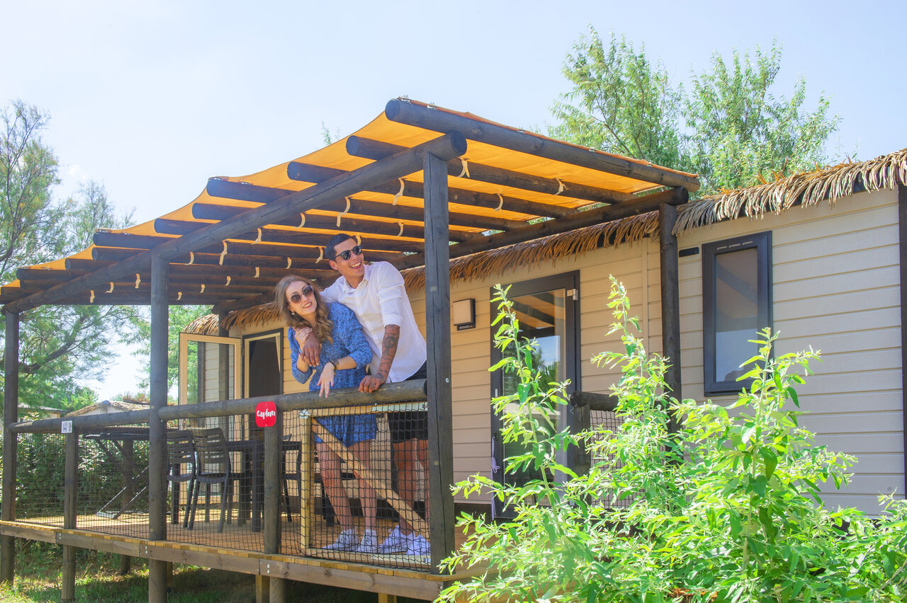 Couple souriant sur la terrasse d'un Mobil-home au camping CAPFUN C�te Vermeille � PORT LA NOUVELLE (11).
