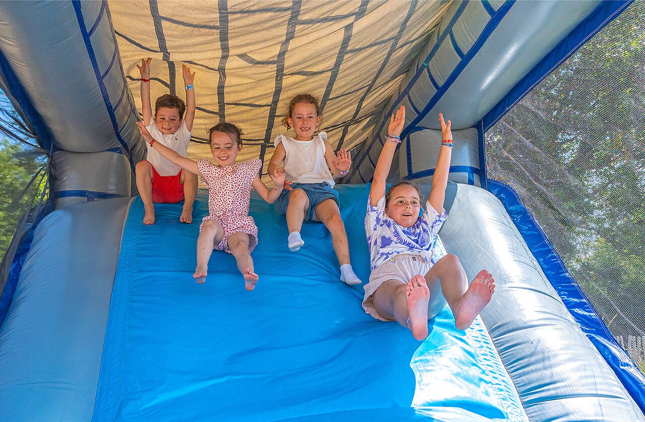 Enfants joyeux sur toboggan gonflable au camping CLICOCHIC Couriou � Recoubeau-Jansac (26).