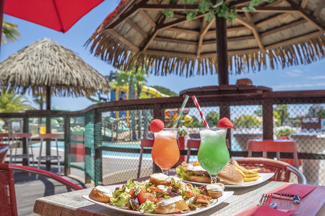 Plats et cocktails sur la terrasse du restaurant avec piscine au camping CAPFUN Curty's � Jard sur Mer (85).