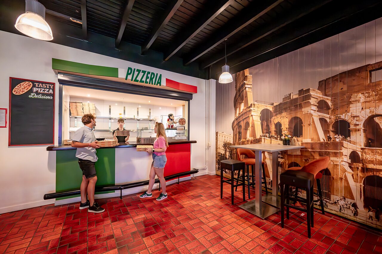 Pizzeria moderne avec clients et personnel au camping CAPFUN De Belten � Rheeze.