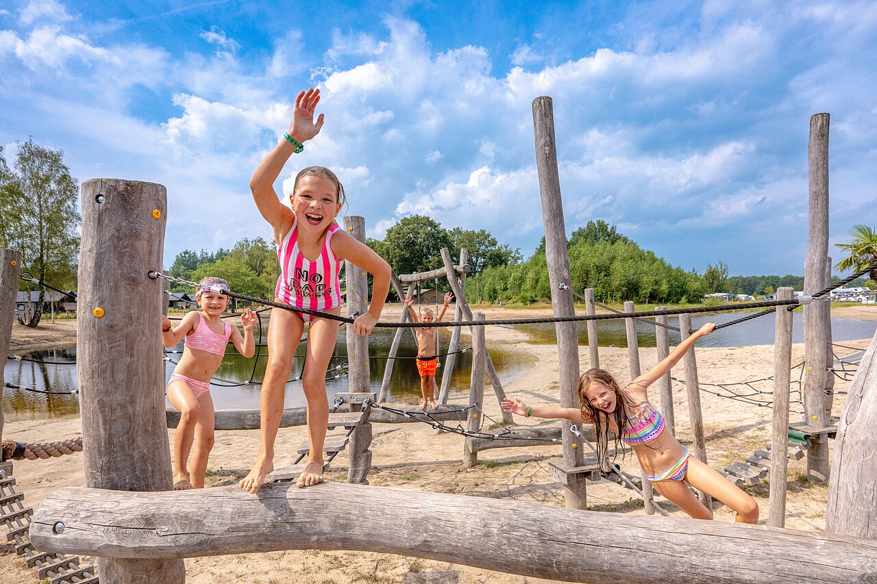 Enfants sur jeux en bois, plage de sable au camping CAPFUN De Belten � Rheeze.