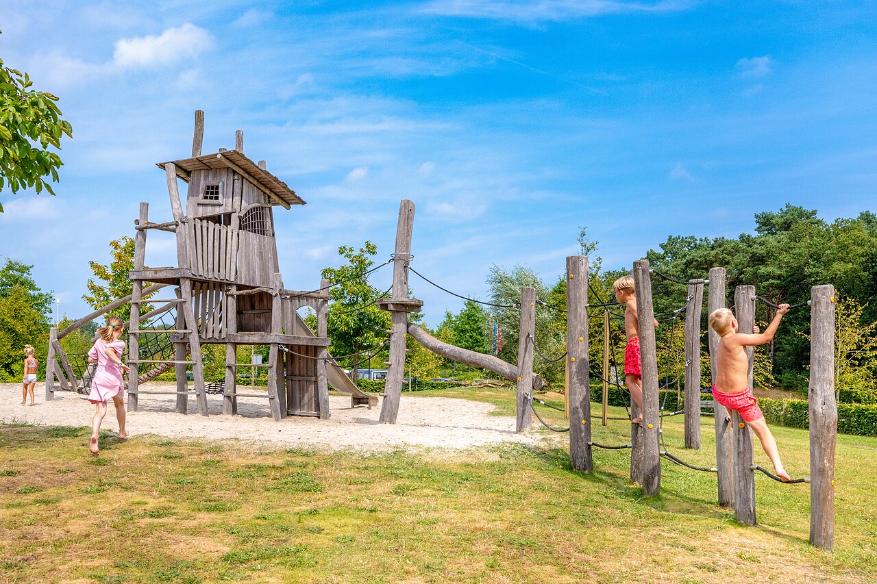 Grande aire de jeux en bois avec enfants grimpant au camping CAPFUN De Belten � Rheeze.