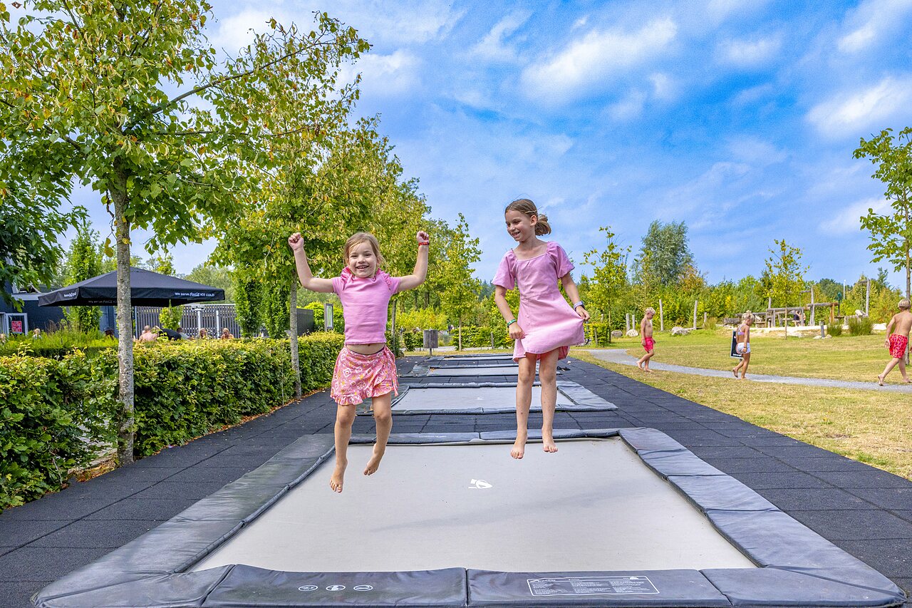 Enfants joyeux sautant sur les trampolines int�gr�s au camping CAPFUN De Belten � Rheeze.