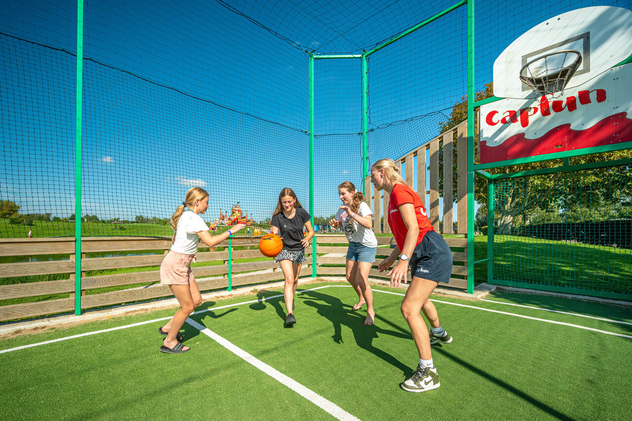 Filles jouant au basketball sur terrain multisport au camping CAPFUN De Bongerd � Tuitjenhorn.