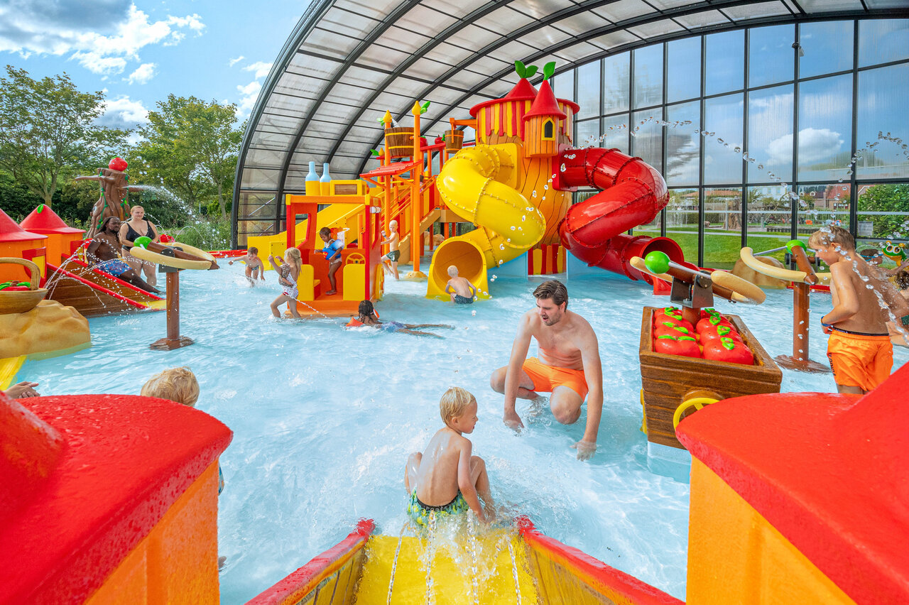 Aire de jeux aquatique couverte avec toboggans color�s et enfants au camping CAPFUN De Bongerd � Tuitjenhorn.