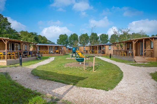 Houten chalets, terrassen en speeltuin op camping CAPFUN De Bongerd in Tuitjenhorn.