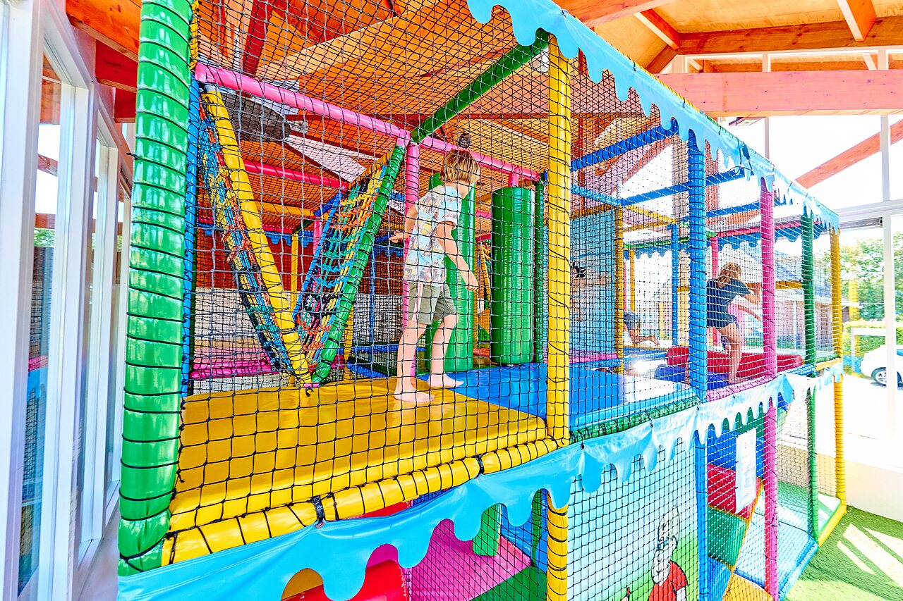 Kleurrijke indoor speeltuin met kinderen op camping CAPFUN De Eikenhof in Paasloo/Oldemarkt.