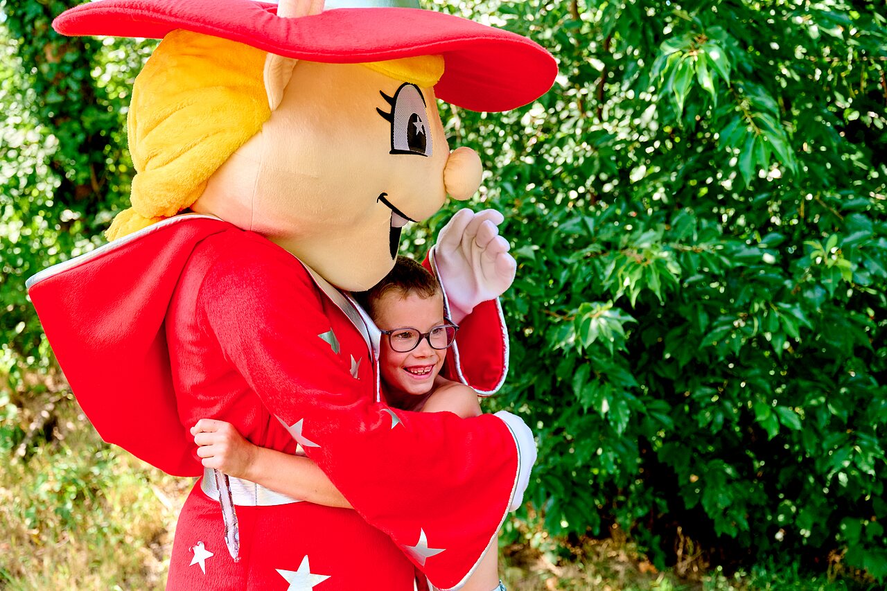 Lachend kind knuffelt de mascotte op camping CAPFUN De Eikenhof in Paasloo/Oldemarkt.