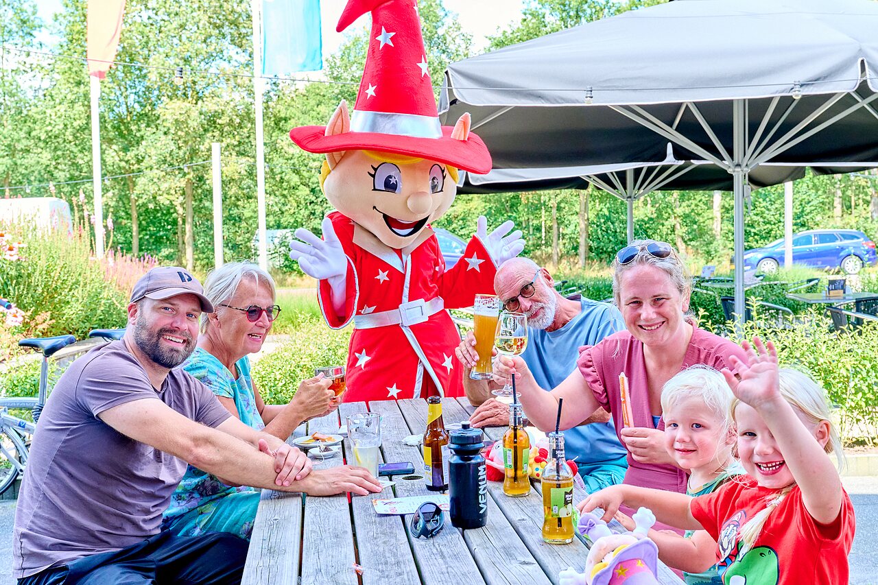 Mascotte, familie en drankjes op het terras van camping CAPFUN De Eikenhof in Paasloo/Oldemarkt.
