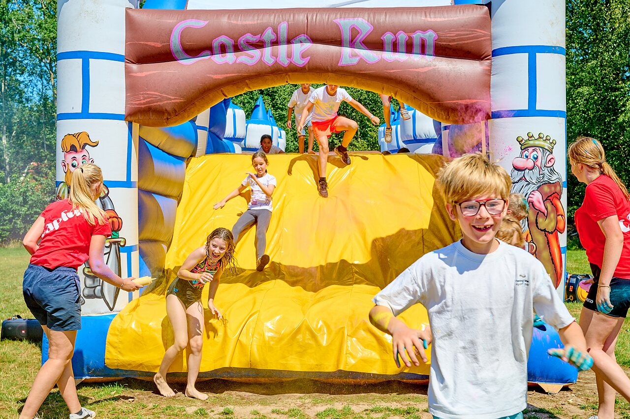 Kinderen op opblaasbare Castle Run op camping CAPFUN De Eikenhof in Paasloo/Oldemarkt.